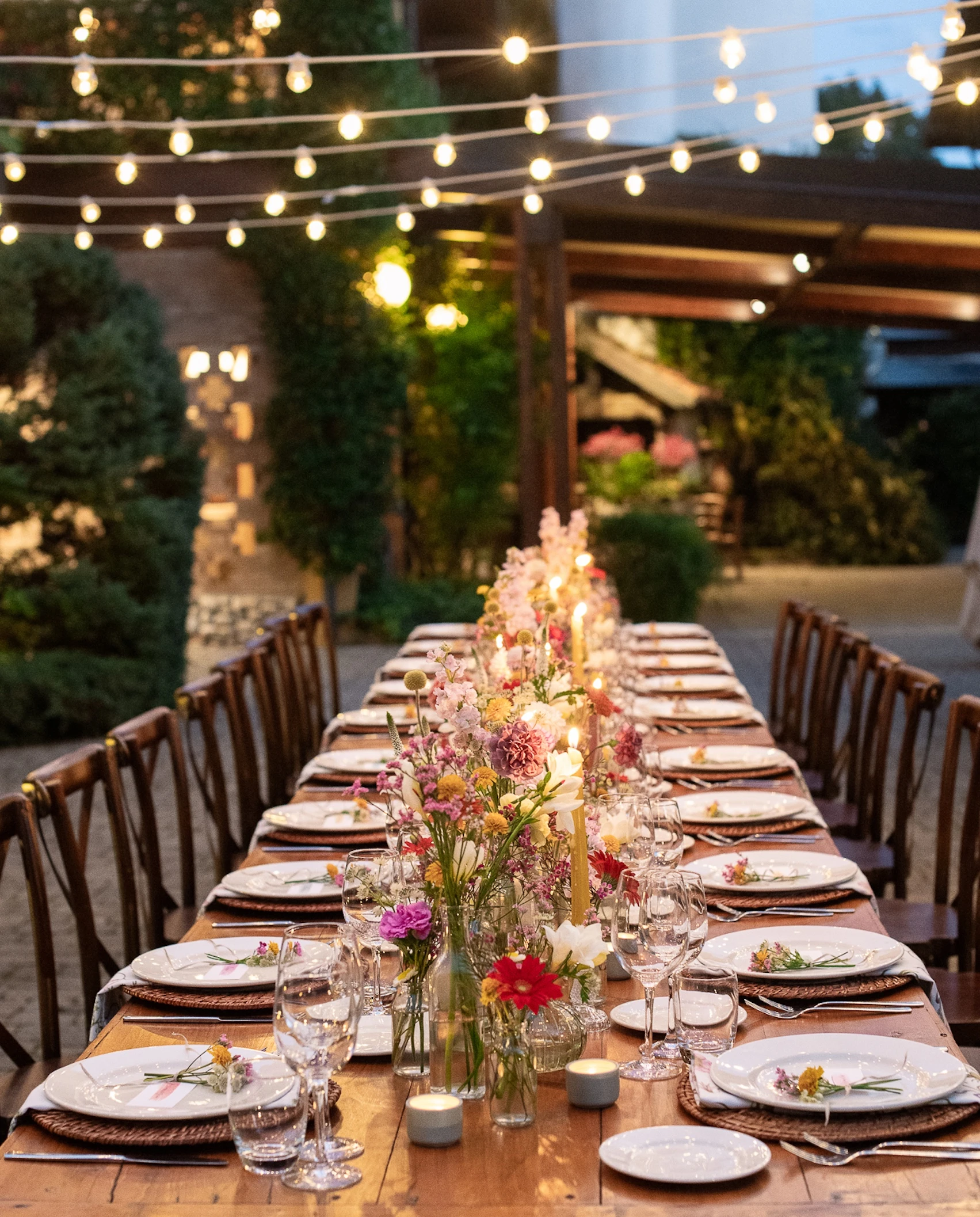 Allestimento cortile del ristorante Corte Gelsi per una cena con tavolo imperiale e fiori